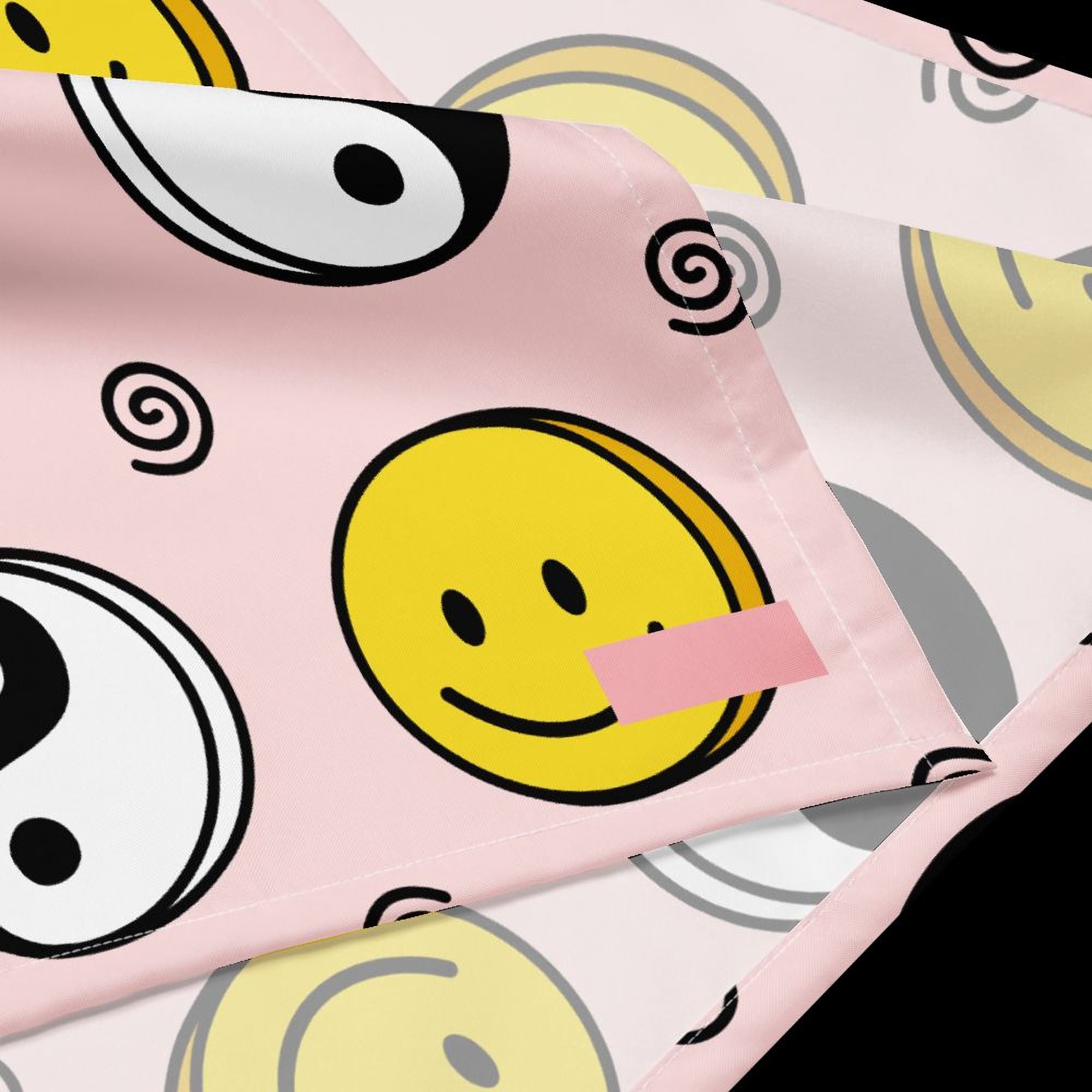 a pink fabric with a repeating pattern of yellow smiley faces and black swirls.