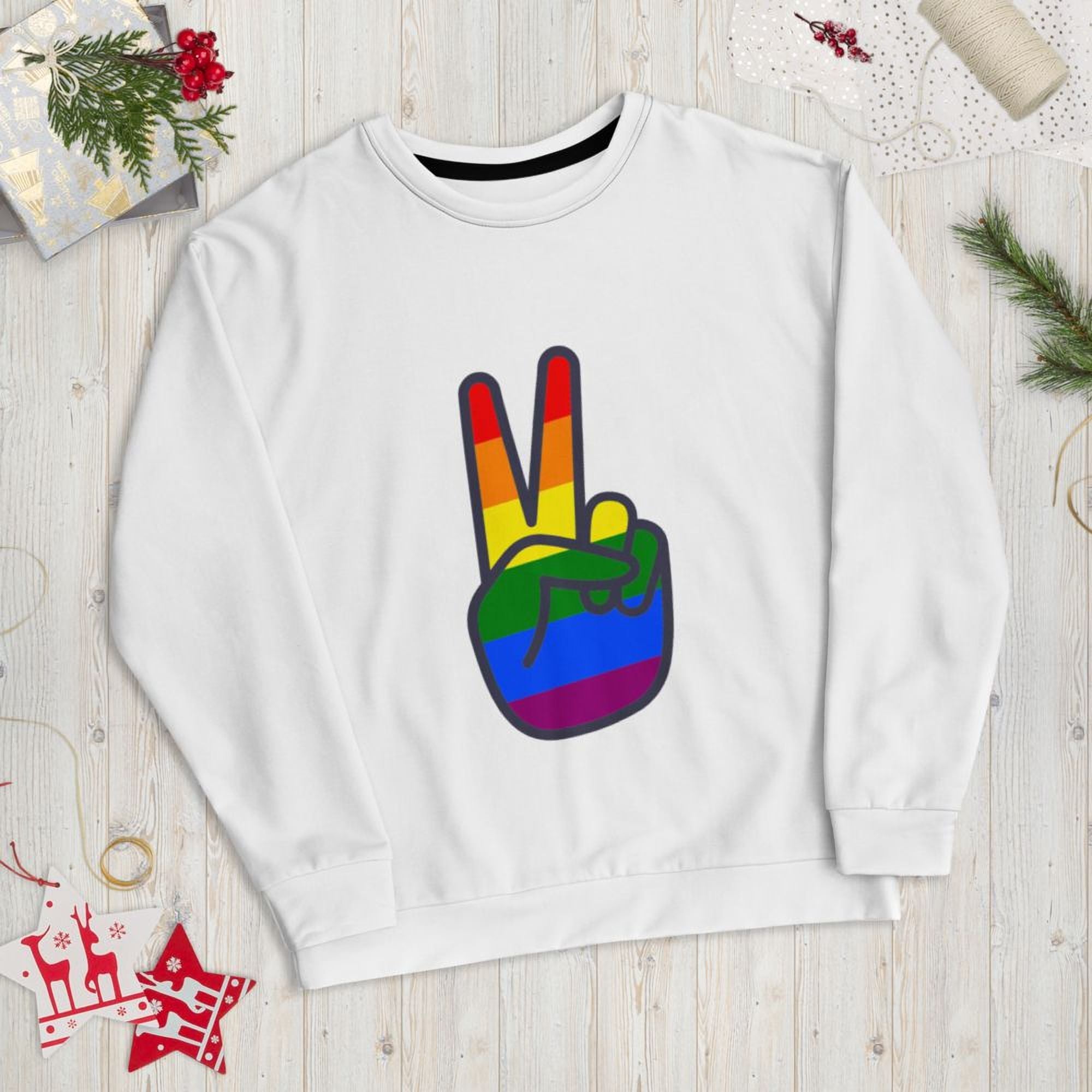 A white sweatshirt with a peace sign graphic and rainbow colors, along with some Christmas decorations and a gift box.