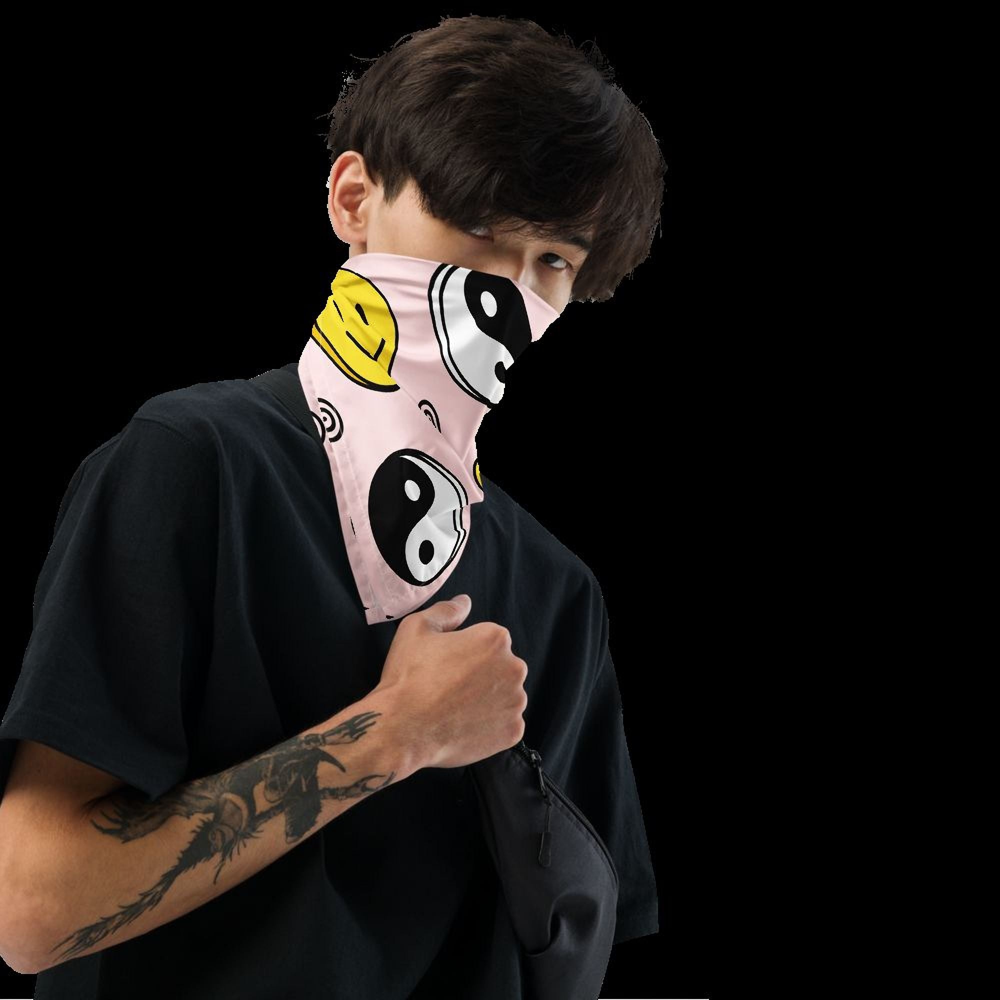 A person wearing a black t-shirt with a colorful bandana around their neck, covering their face.