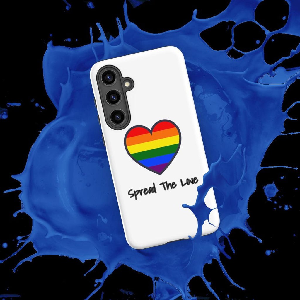 A white phone case with a rainbow heart and the text "Spread The Love" printed on it, placed on a splash of blue liquid.